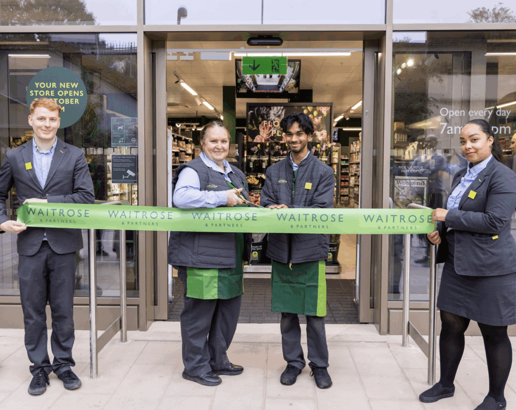 Partners outside new shop cutting the opening ribbon.