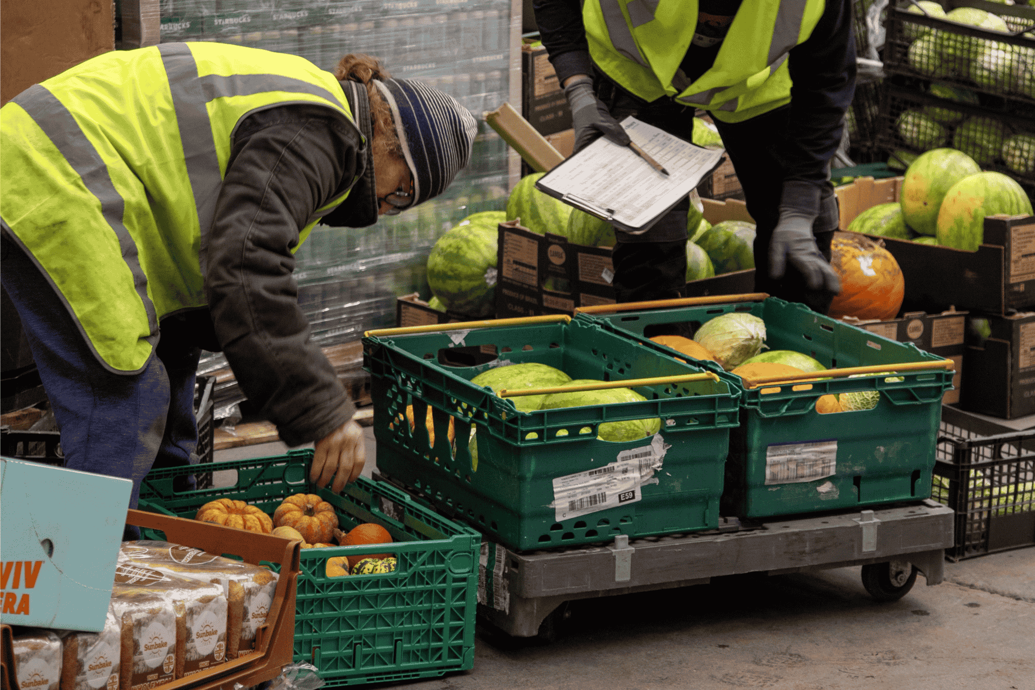 Man working in a warehouse loads crates with food.