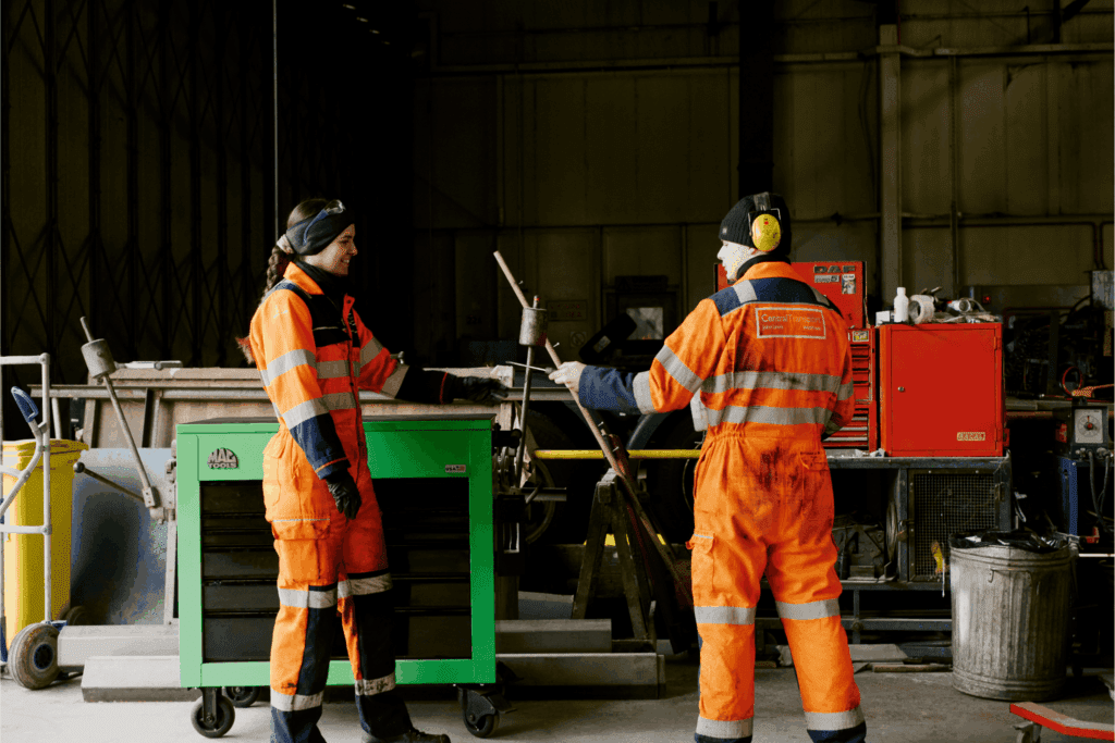A picture of Betty and a colleague chatting in the workshop.
