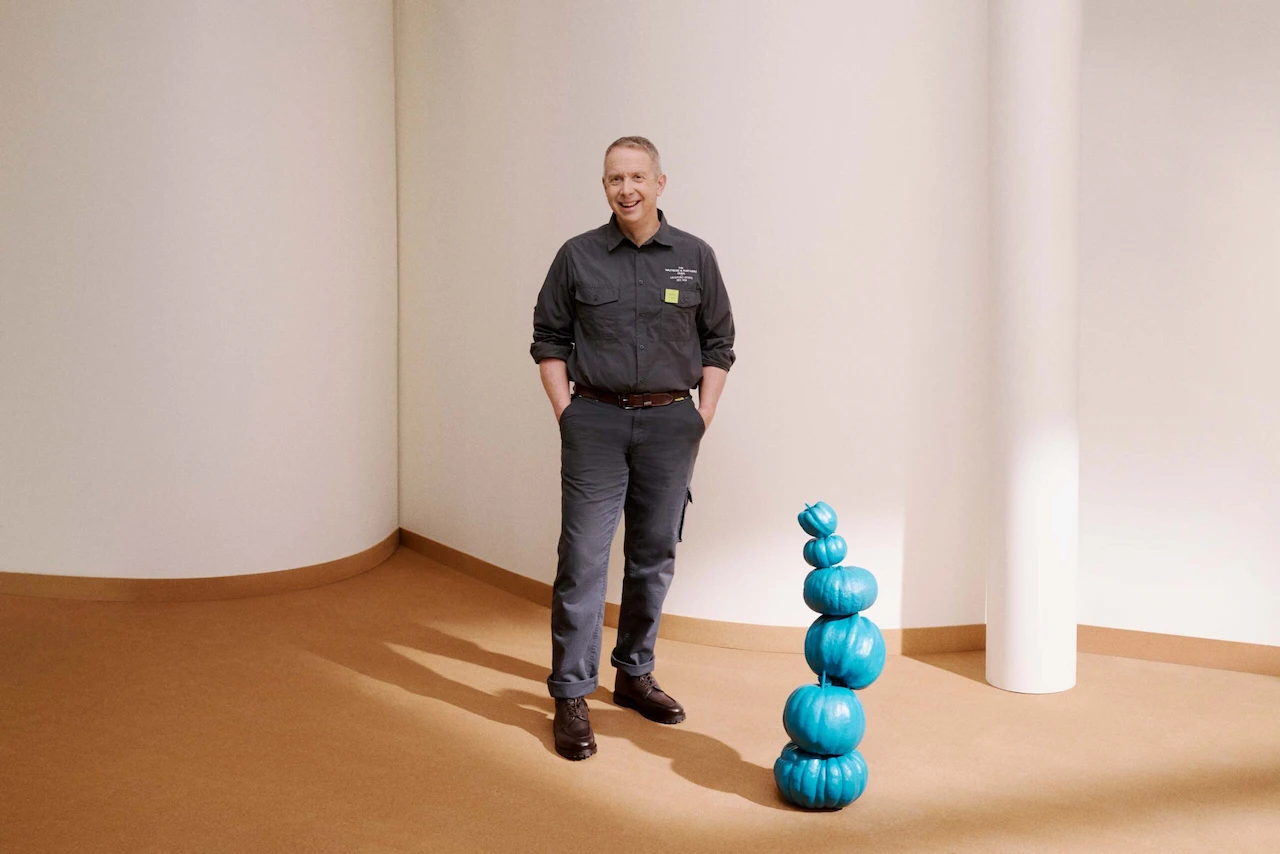 John stood on a photoset with a stack of blue pumpkins next to him. 