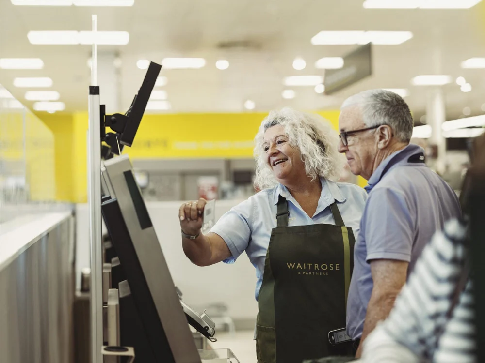 Waitrose employee helping client at till